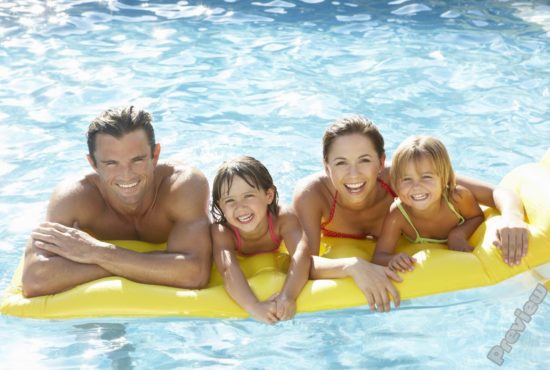 Mother and father having fun with kids in the pool