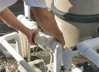 A man repairing pool pipes